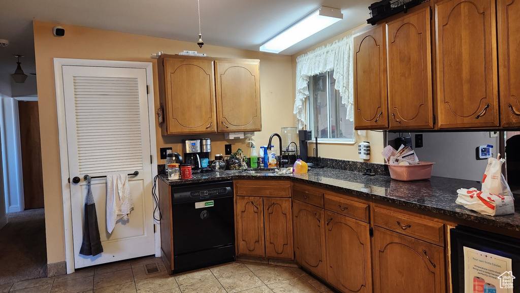 Kitchen with black dishwasher, brown cabinets, and a sink