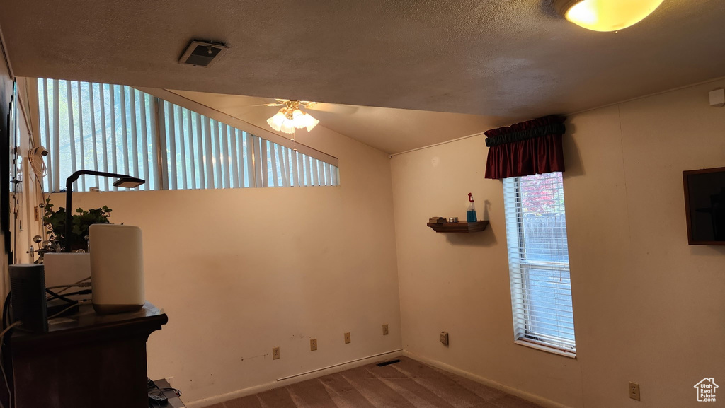 Interior space featuring baseboards, a healthy amount of sunlight, ceiling fan, and a textured ceiling