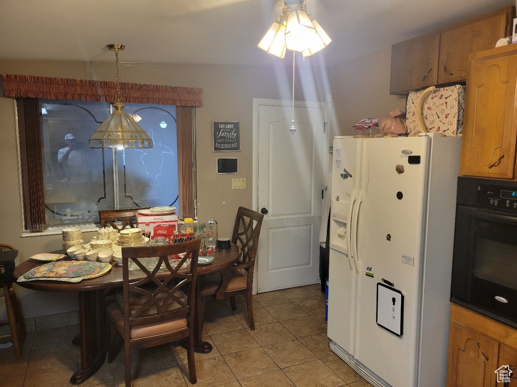 Dining space with light tile patterned floors and a ceiling fan