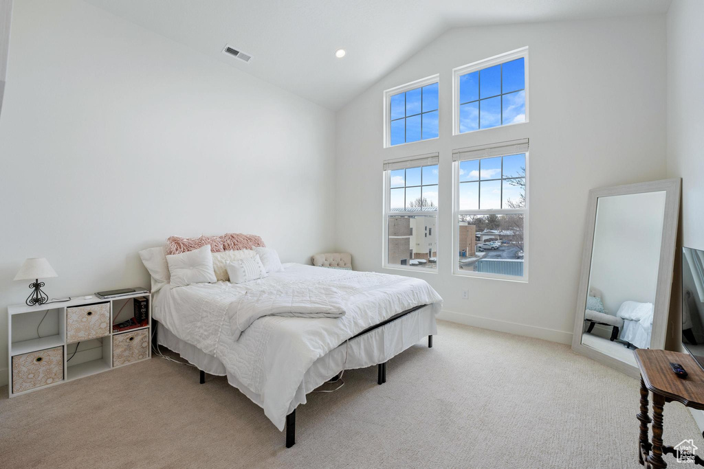 Carpeted bedroom with recessed lighting, baseboards, visible vents, and high vaulted ceiling