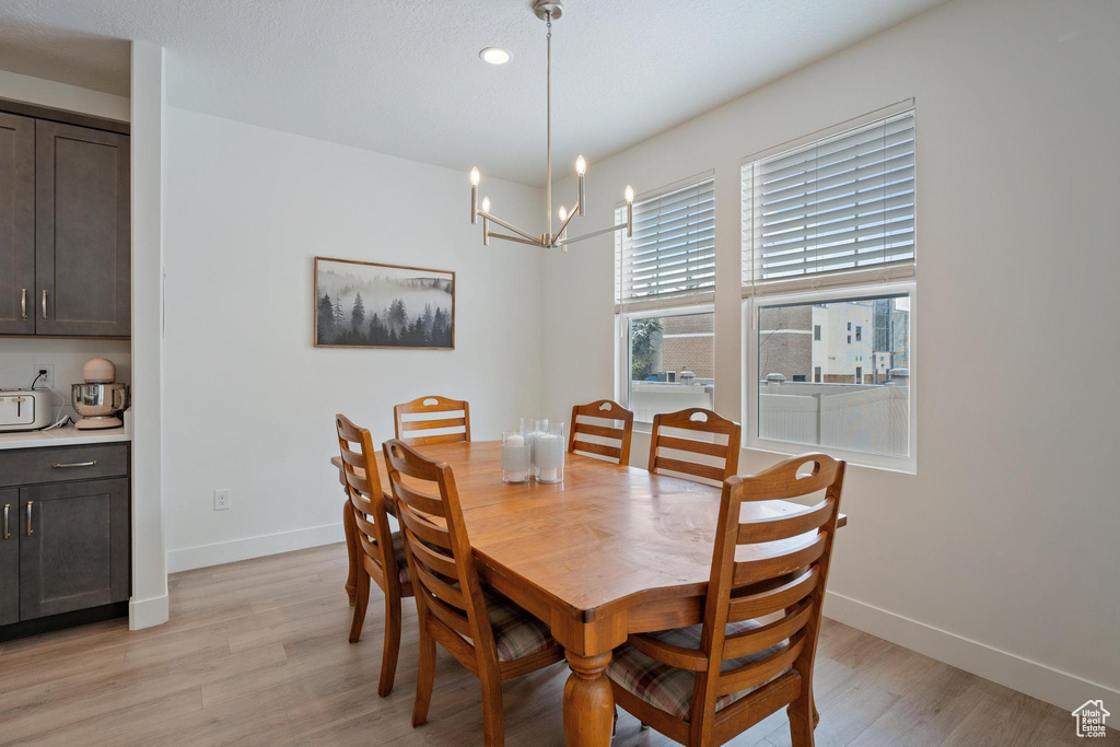 Dining space with a chandelier, recessed lighting, light wood finished floors, and baseboards