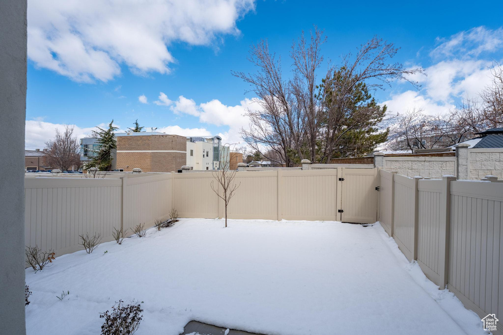 Yard covered in snow with a fenced backyard and a gate