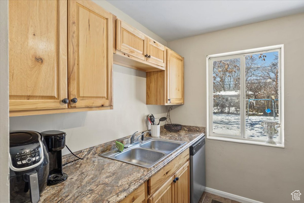 Kitchen with stainless steel dishwasher, a healthy amount of sunlight, light brown cabinets, and a sink