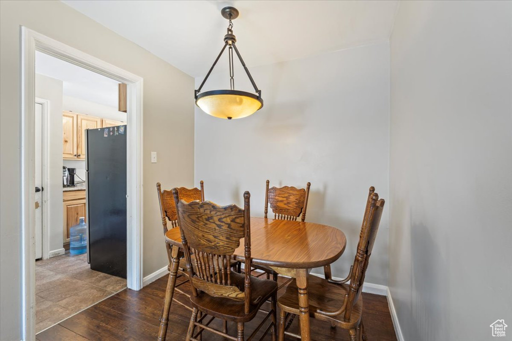 Dining room with dark wood finished floors and baseboards