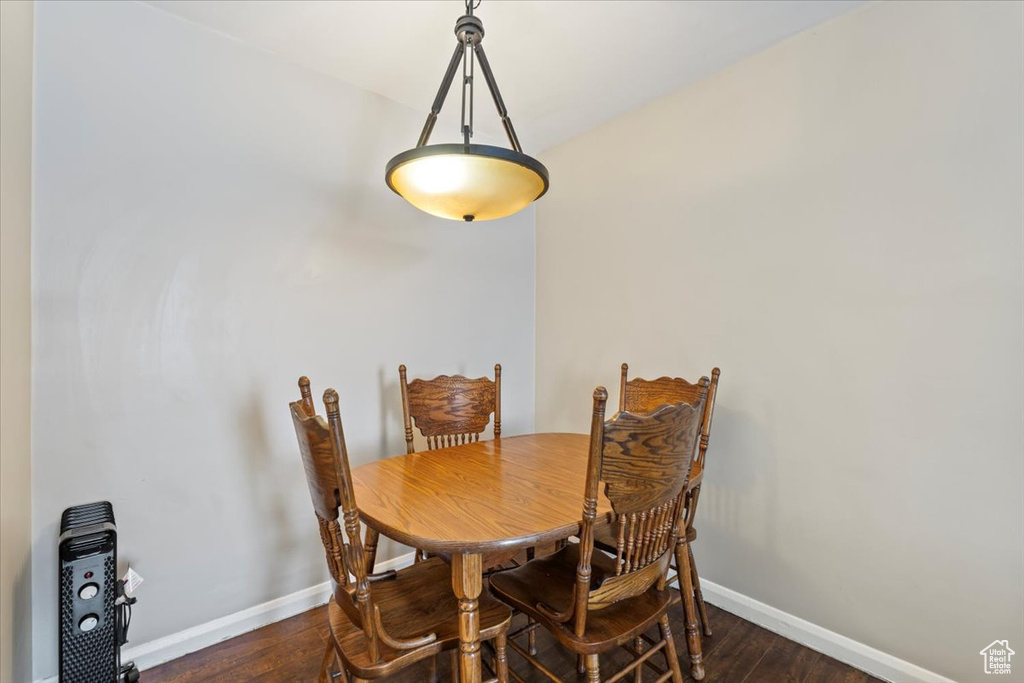Dining room with dark wood-style floors and baseboards