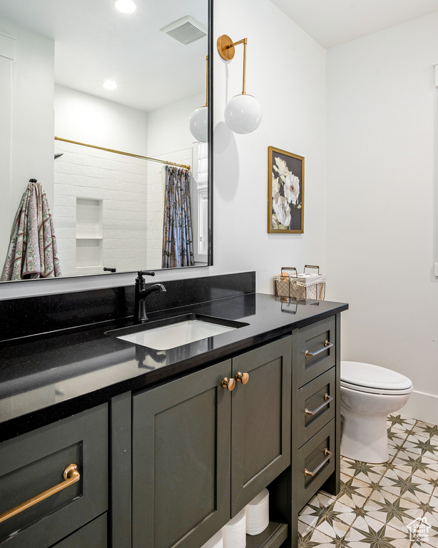 Bathroom featuring vanity, visible vents, recessed lighting, tile patterned floors, and toilet