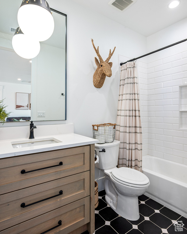 Full bath with visible vents, shower / tub combo, toilet, and vanity