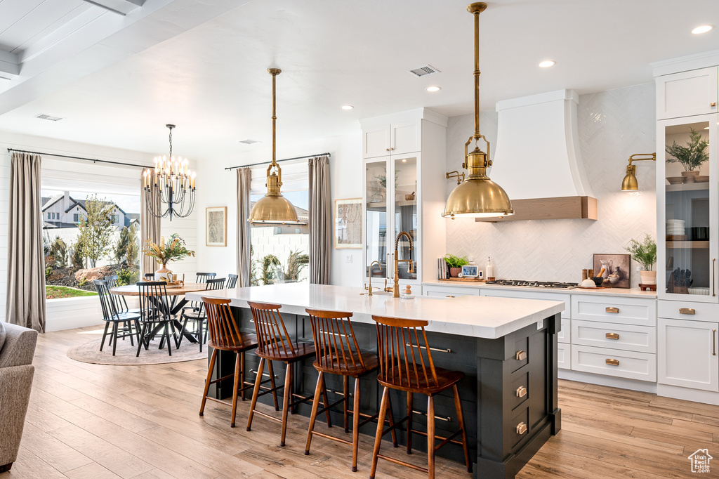 Kitchen featuring premium range hood, visible vents, and white cabinetry