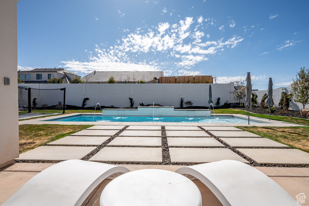 View of pool with a fenced in pool, fence, and a patio area