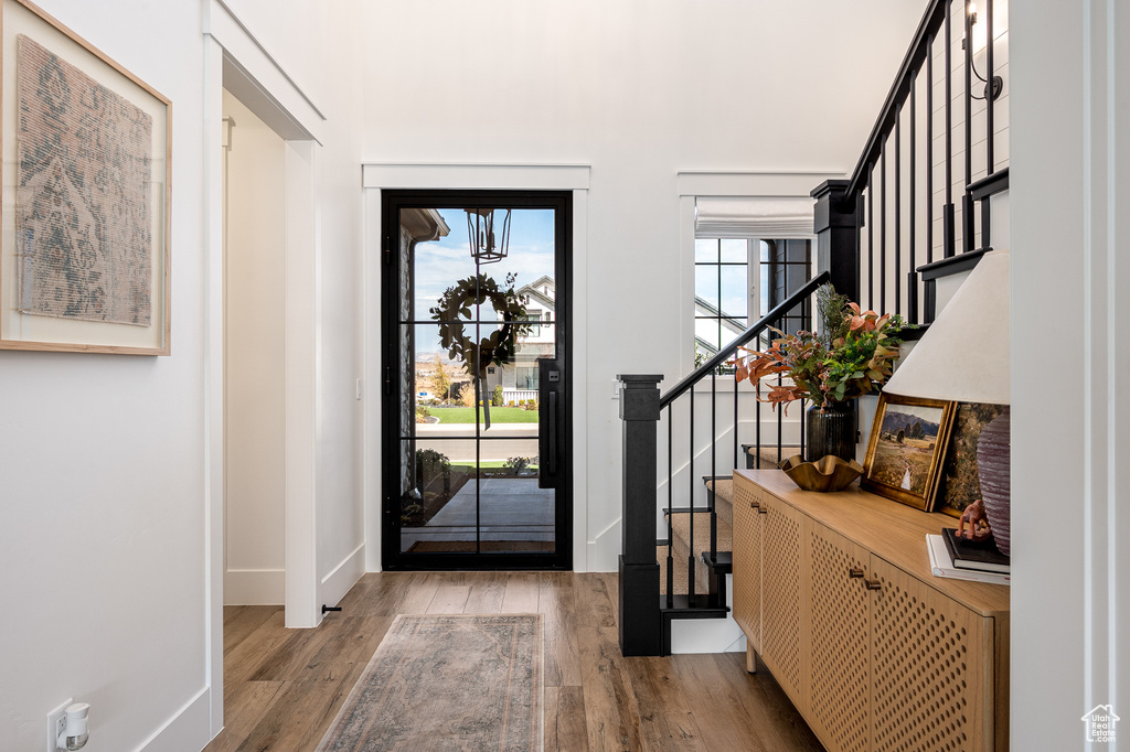 Entrance foyer featuring stairway, baseboards, and wood finished floors