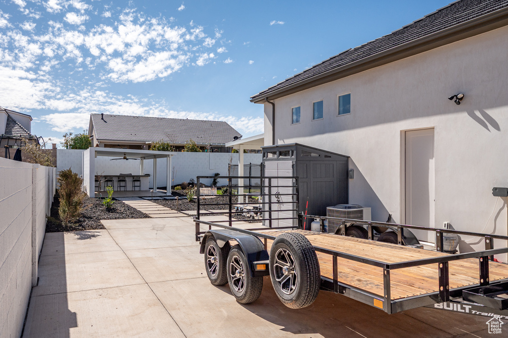 View of patio with an outdoor structure and a fenced backyard