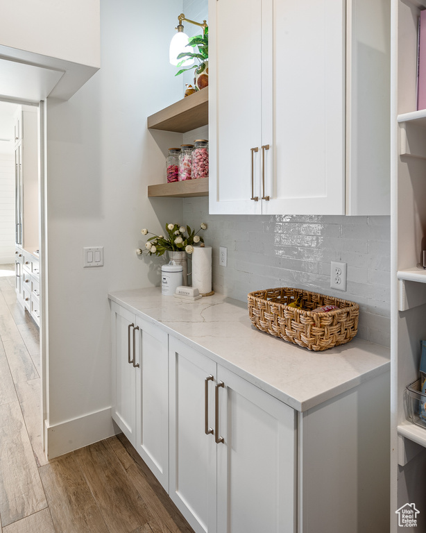 Bar with baseboards, tasteful backsplash, and wood finished floors