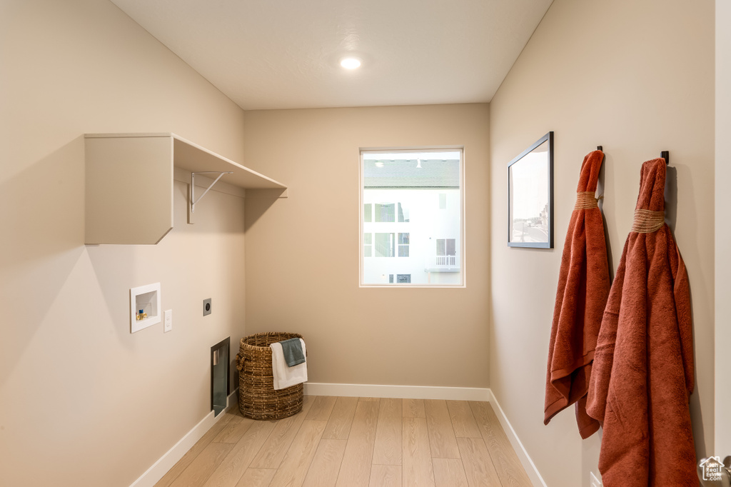 Laundry room featuring baseboards, laundry area, hookup for a washing machine, wood finished floors, and electric dryer hookup