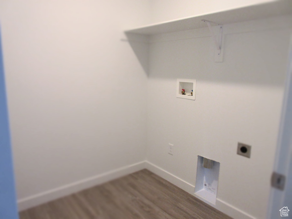Clothes washing area featuring electric dryer hookup, dark wood-type flooring, baseboards, hookup for a washing machine, and laundry area