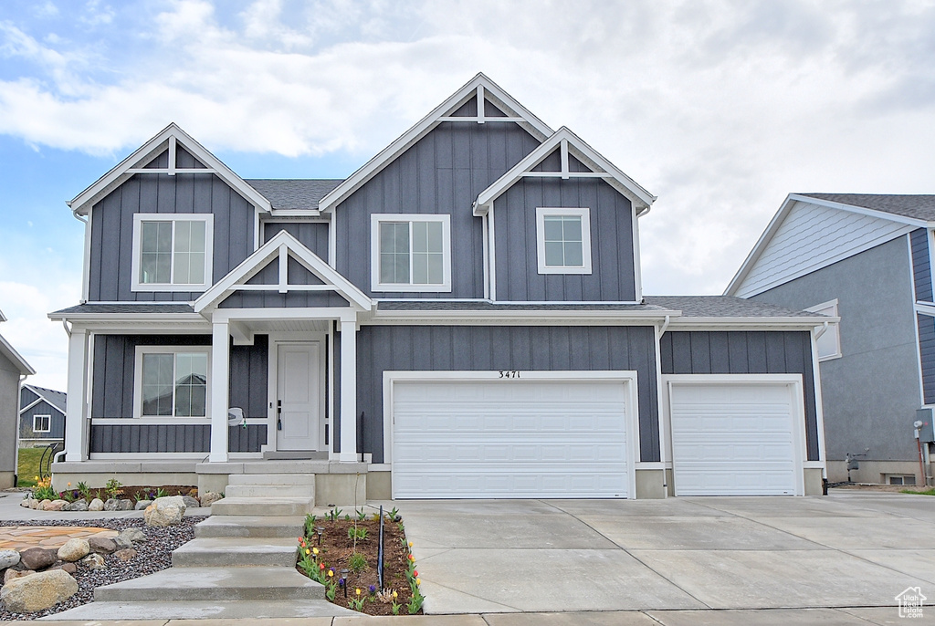 Craftsman-style home featuring concrete driveway, an attached garage, and board and batten siding
