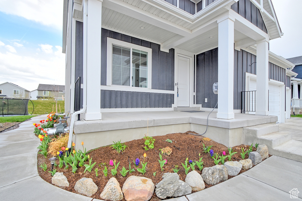 Property entrance with board and batten siding and a porch