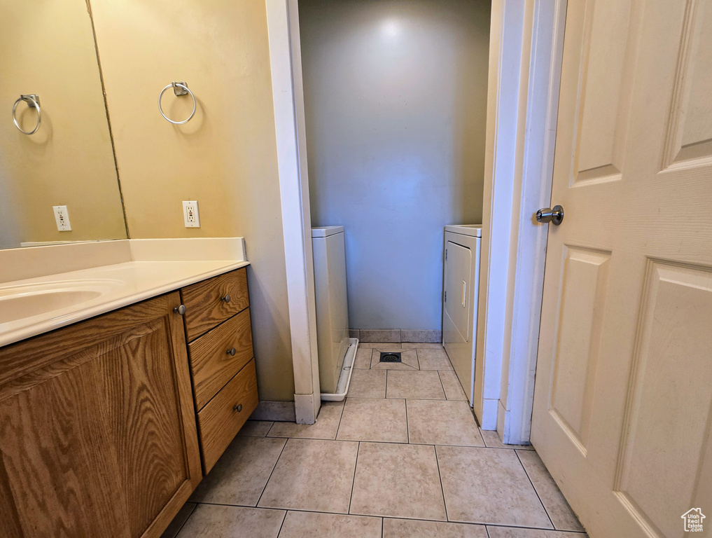 Bathroom featuring washer and dryer, tile patterned floors, and vanity