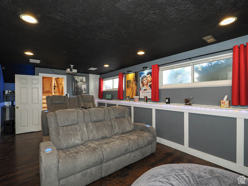 Home theater room with recessed lighting, visible vents, a textured ceiling, and wood finished floors