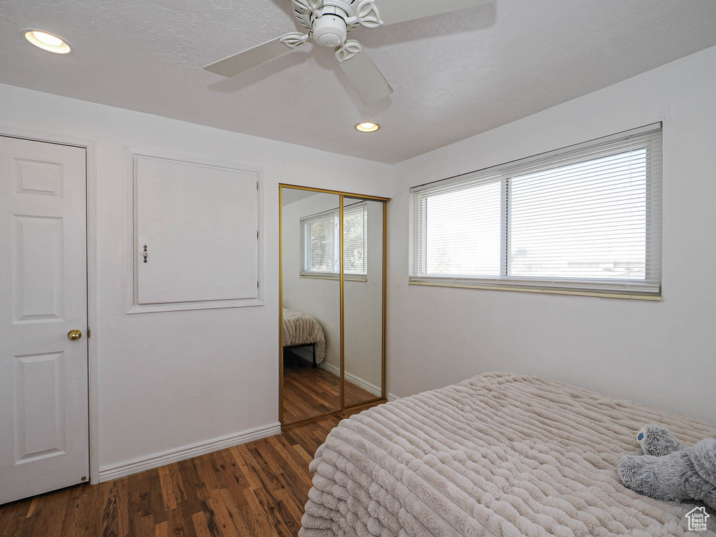 Bedroom with wood finished floors, baseboards, recessed lighting, ceiling fan, and a closet