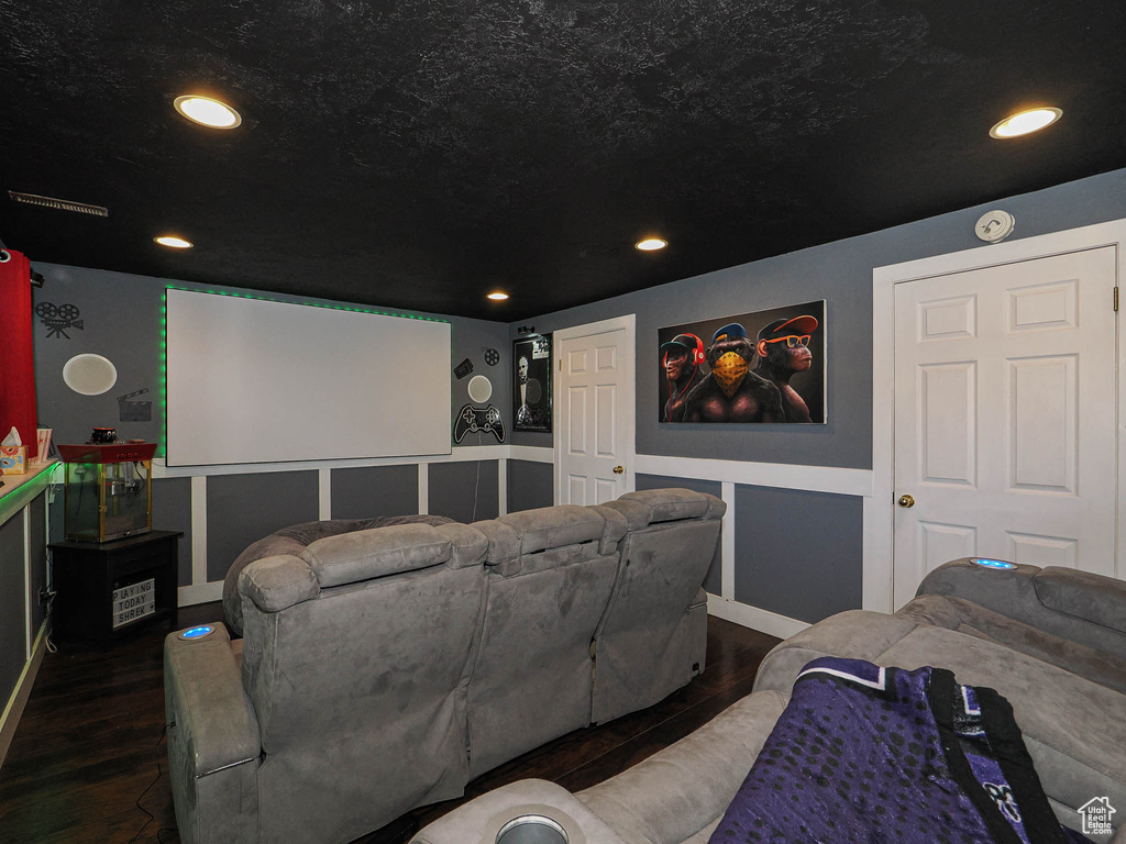 Home theater featuring recessed lighting, a textured ceiling, and wood finished floors