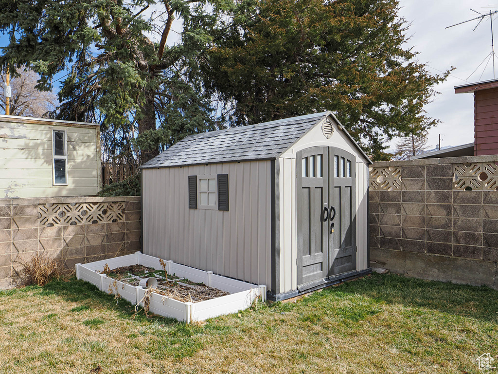 View of shed featuring a vegetable garden and a fenced backyard