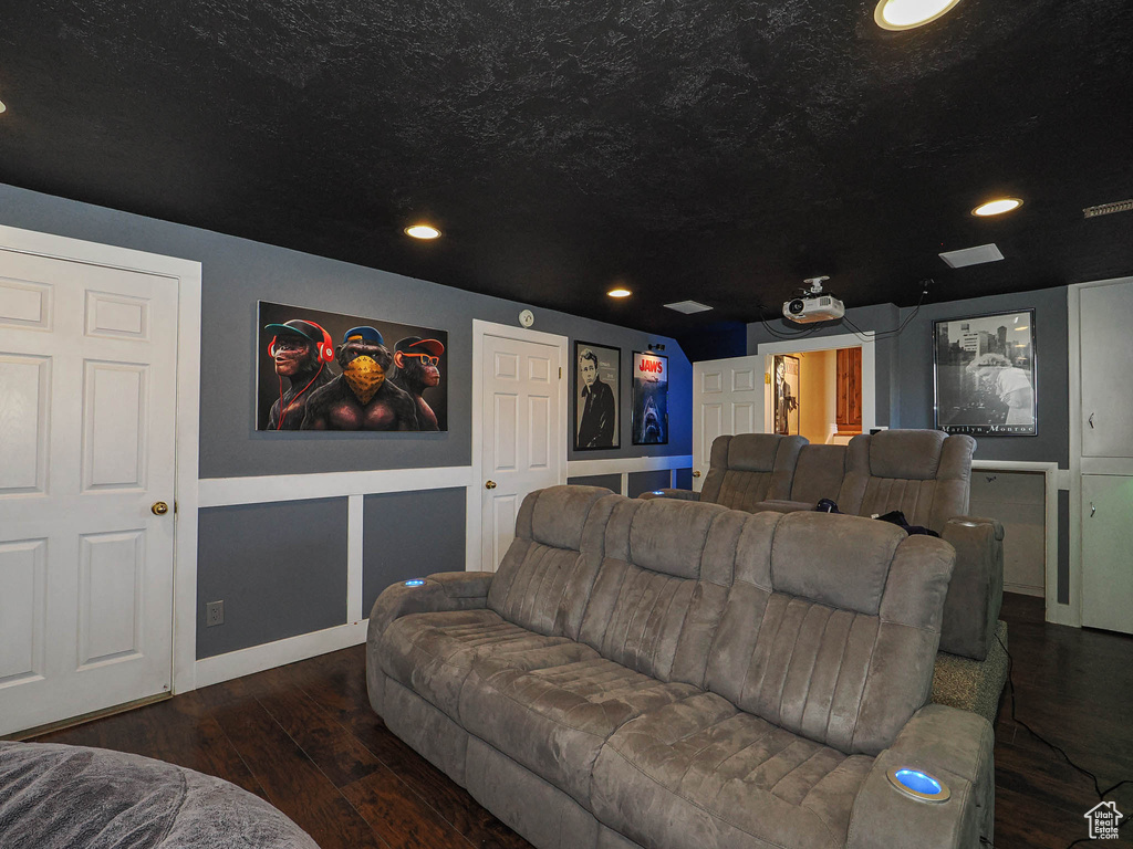 Home theater room with recessed lighting, a textured ceiling, baseboards, and wood finished floors