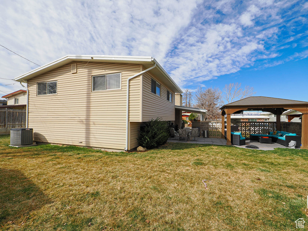 View of home\'s exterior with a lawn, an outdoor living space, a patio, fence, and a gazebo