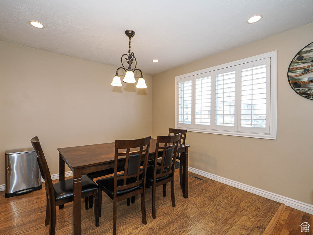 Dining room featuring recessed lighting, a notable chandelier, wood finished floors, and baseboards
