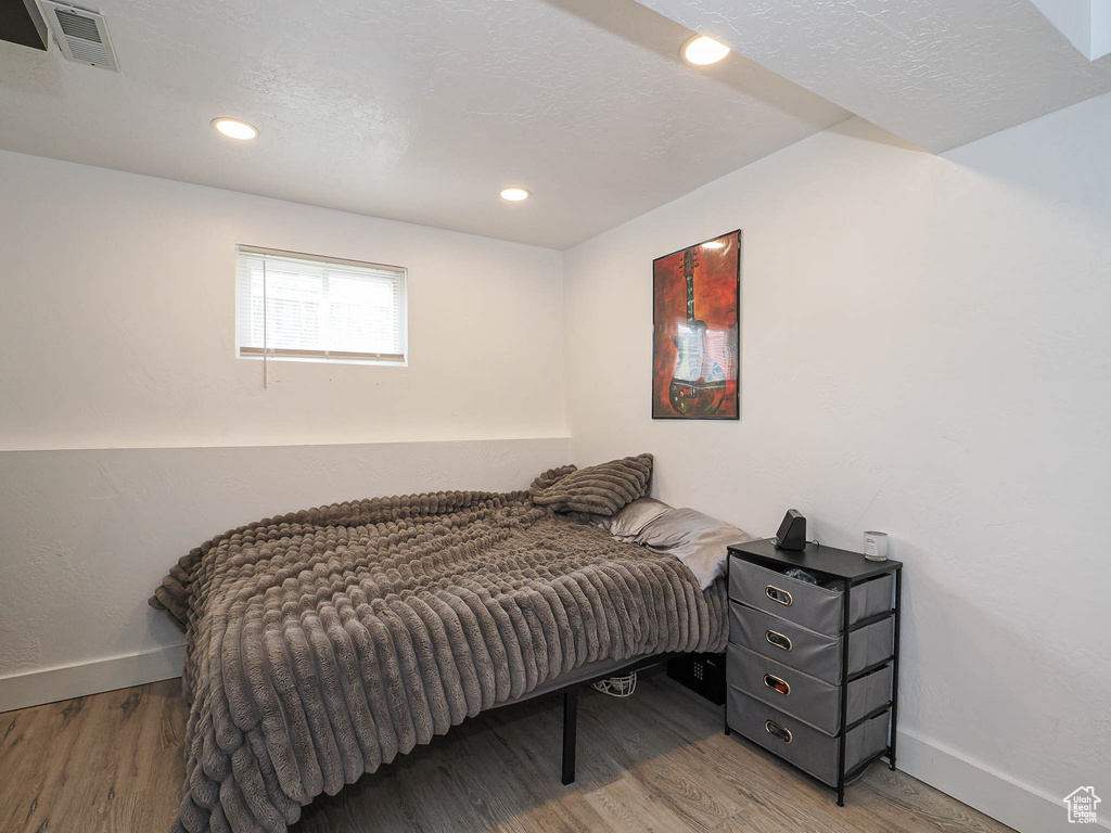 Bedroom featuring visible vents, baseboards, and wood finished floors
