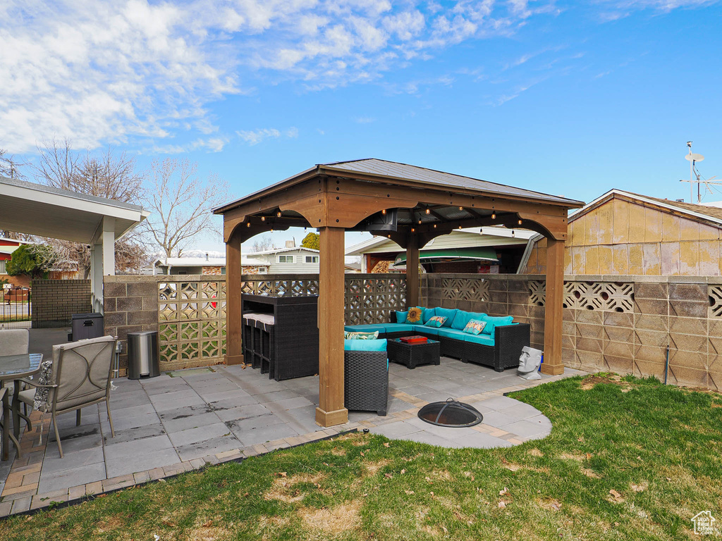 View of patio featuring an outdoor living space with a fire pit, a gazebo, and fence