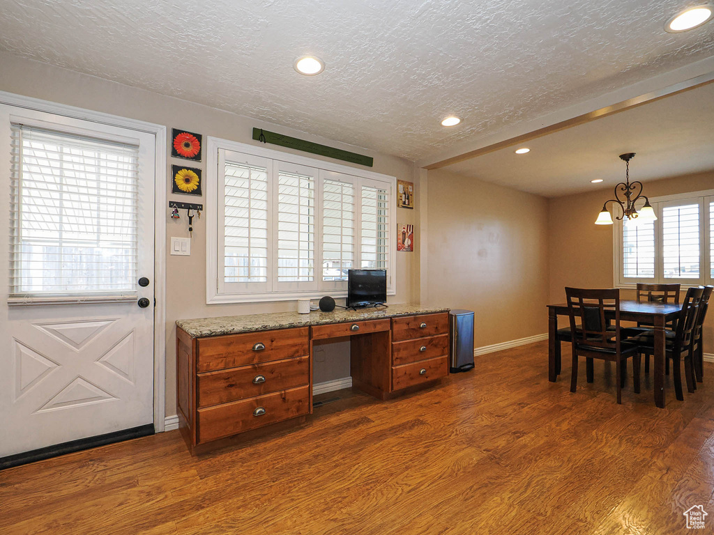 Office area with recessed lighting, a textured ceiling, an inviting chandelier, and dark wood-style flooring