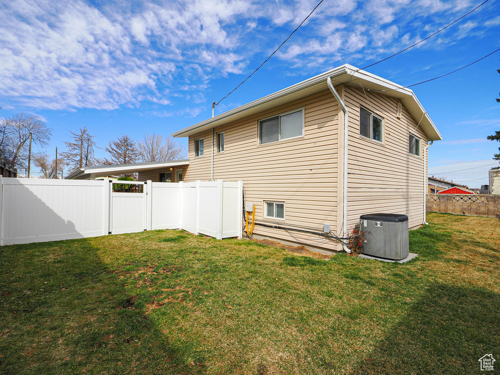 View of side of home featuring a lawn and a fenced backyard