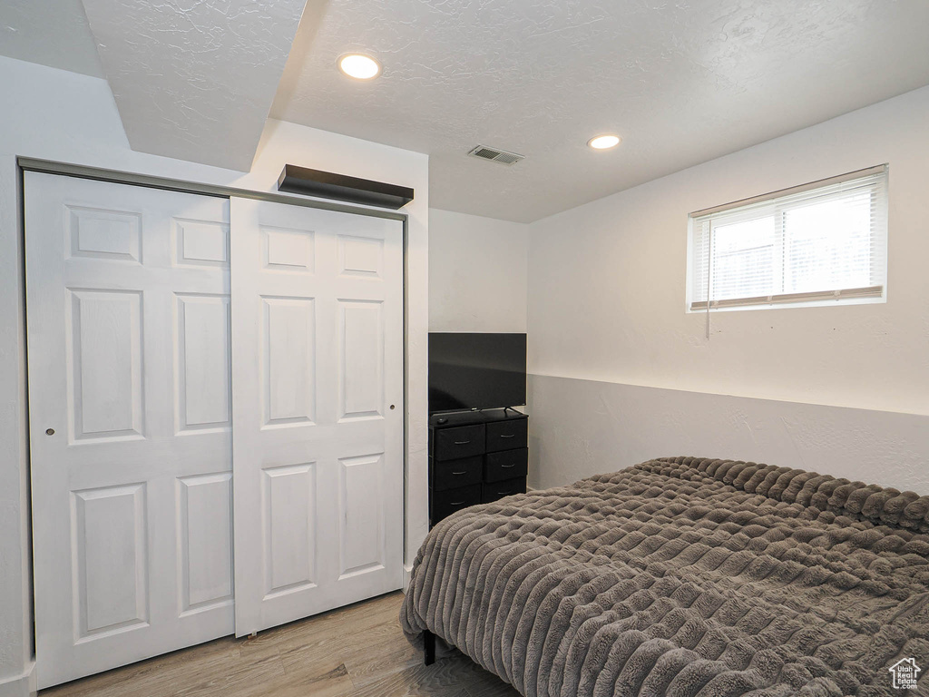 Bedroom featuring visible vents, recessed lighting, light wood-style flooring, a closet, and a textured ceiling