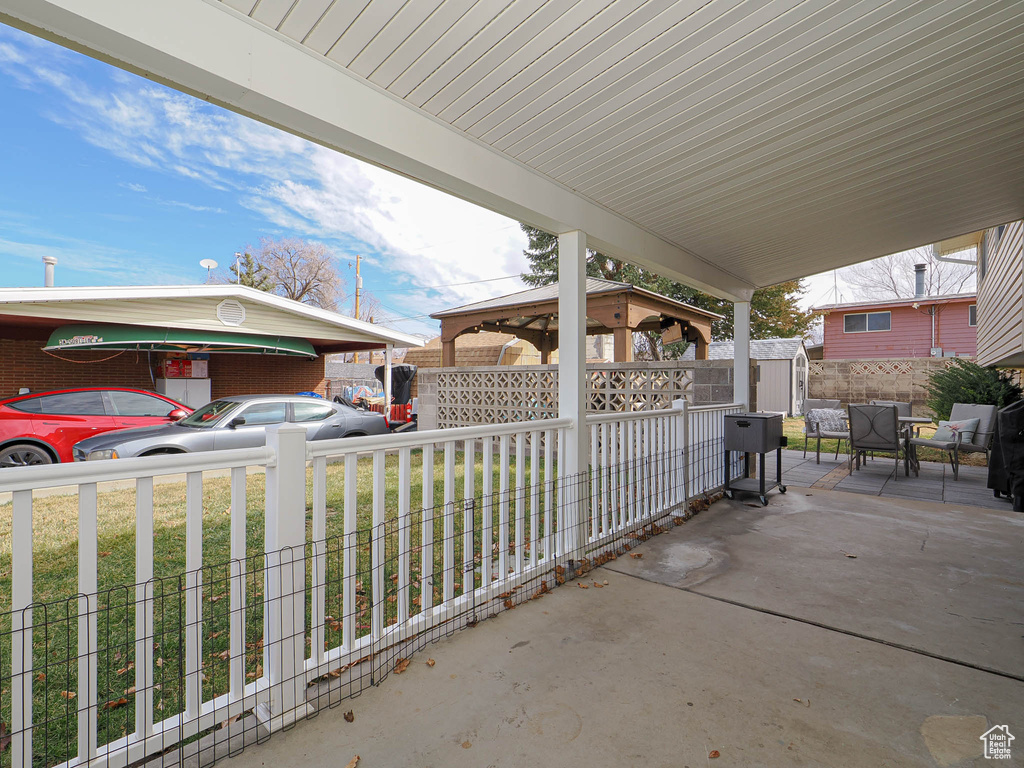 View of patio / terrace with a gazebo, an outbuilding, fence, and a shed