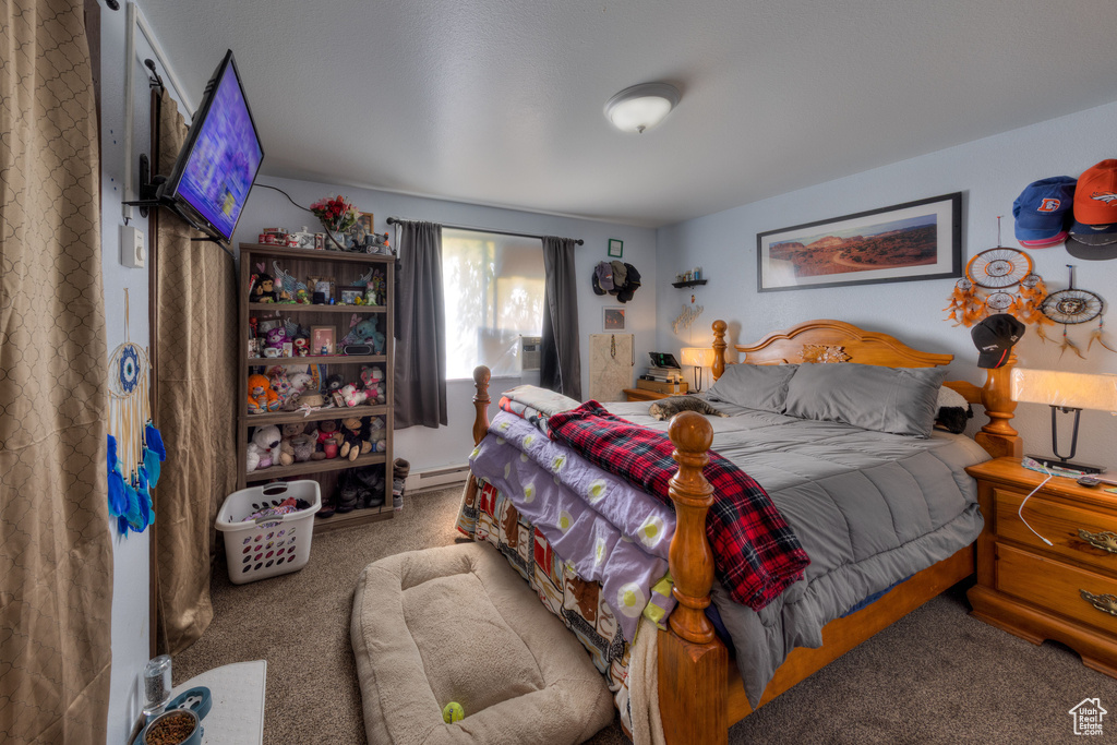Carpeted bedroom featuring baseboard heating