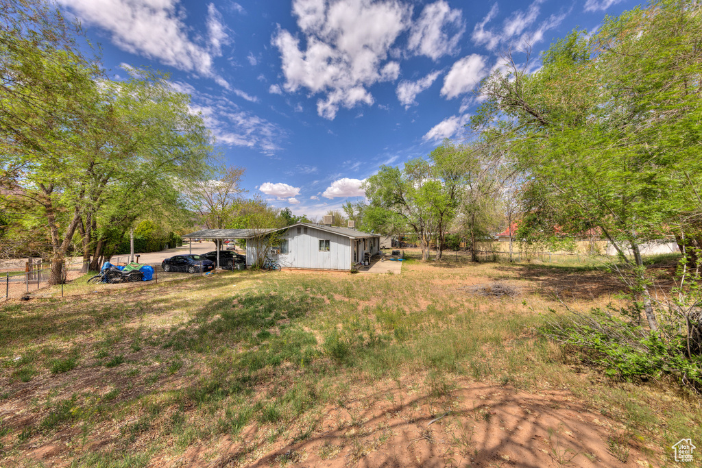View of yard featuring a carport and fence