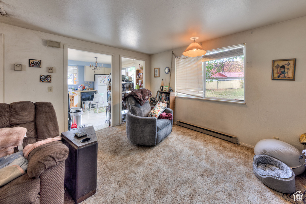 Carpeted living room with a notable chandelier and a baseboard heating unit