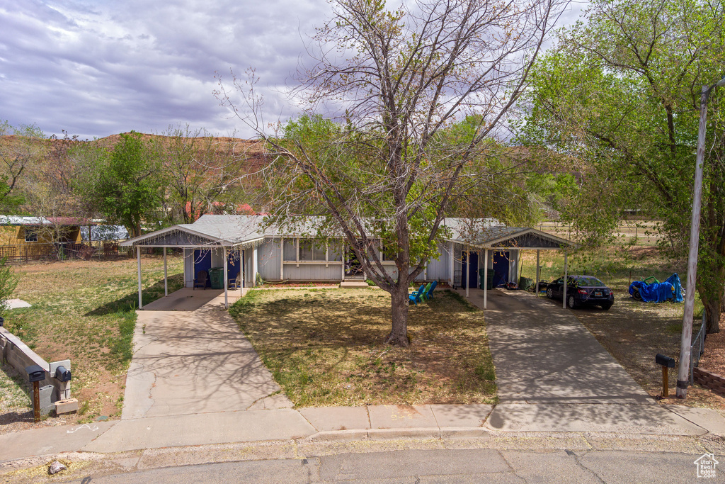 Ranch-style home featuring concrete driveway and an attached carport