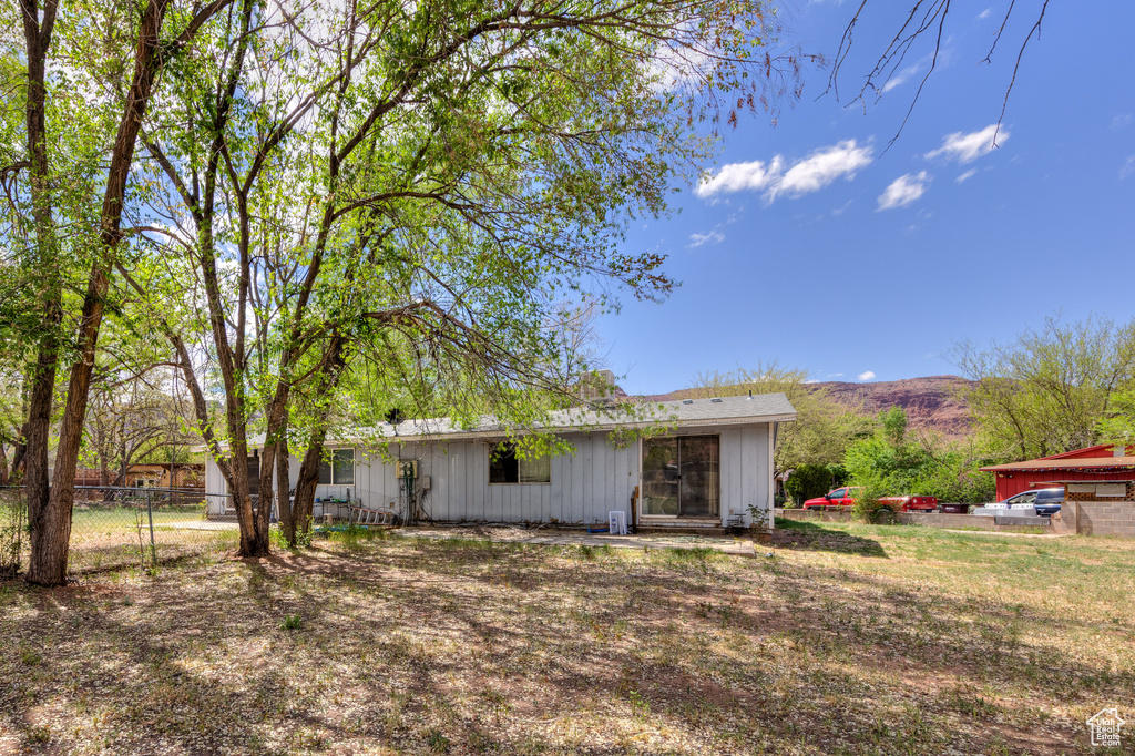 View of front of house with a mountain view and fence