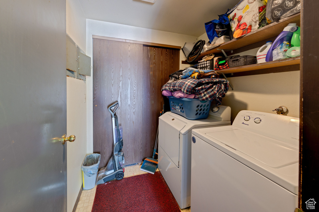 Washroom with light floors, independent washer and dryer, and laundry area