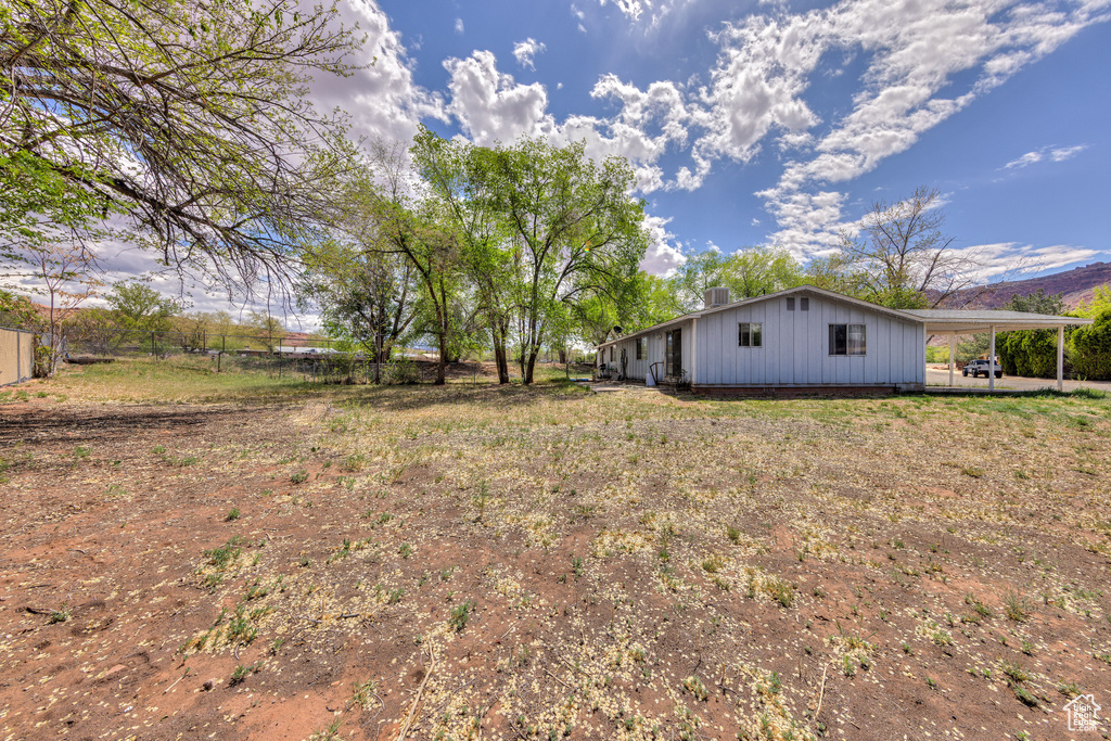 View of yard with a carport and fence