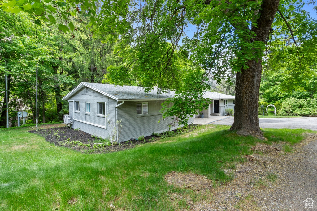 View of front of house featuring brick siding, driveway, and a front yard