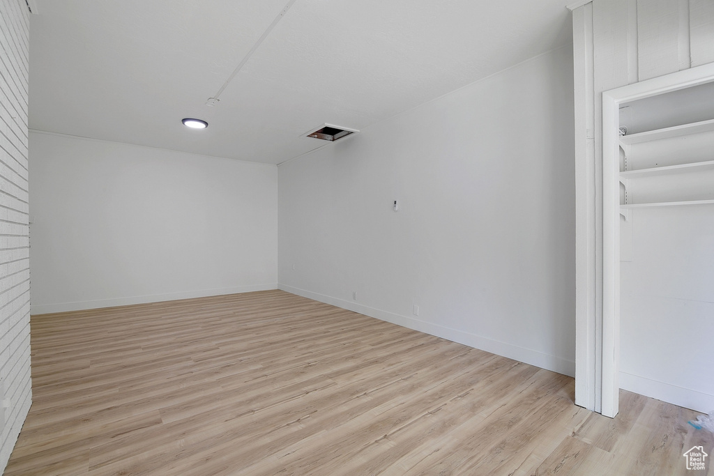 Empty room featuring light wood-style floors, visible vents, and baseboards