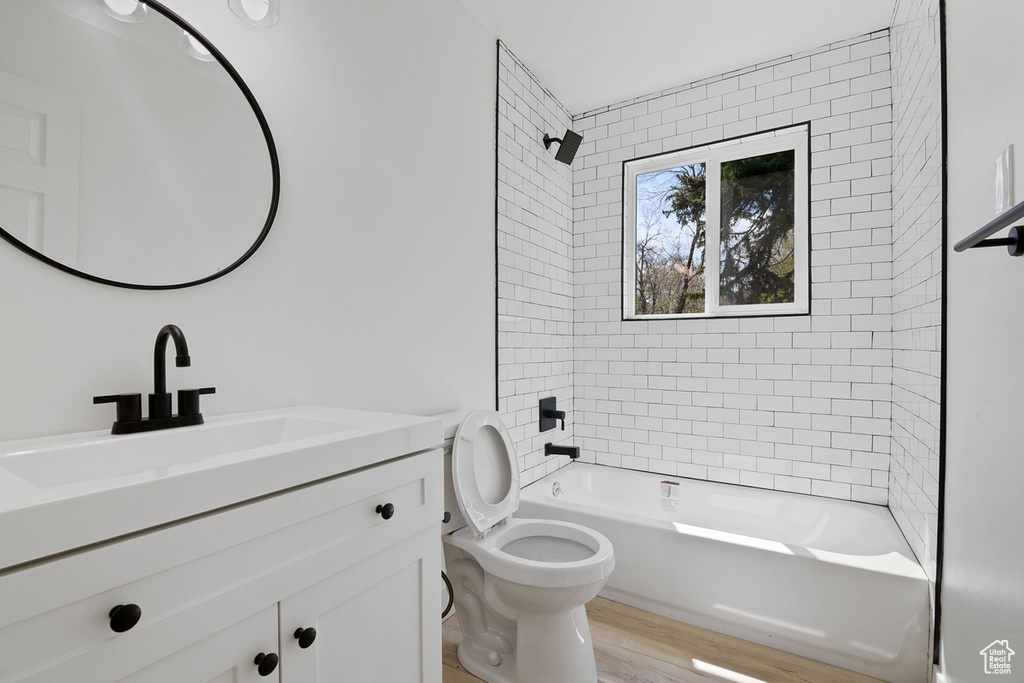 Full bathroom featuring toilet, shower / washtub combination, wood finished floors, and vanity