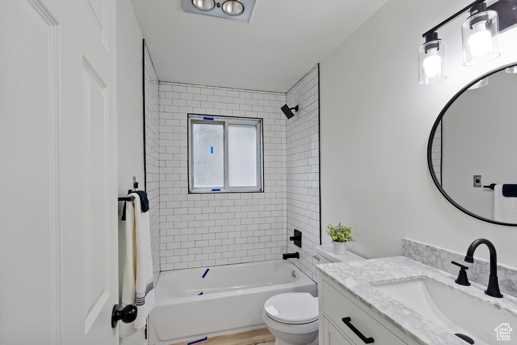 Bathroom featuring shower / bathtub combination, toilet, vanity, and wood finished floors