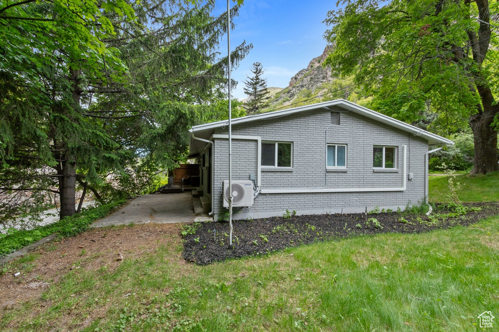 View of side of home with a yard and brick siding
