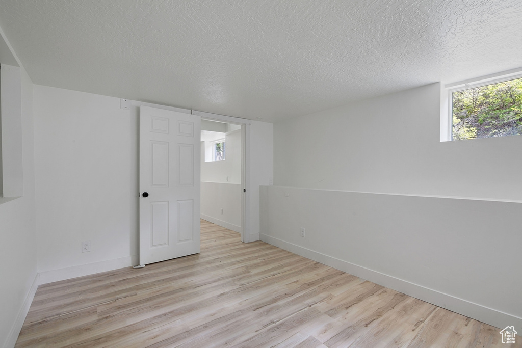 Spare room with a healthy amount of sunlight and light wood-style flooring