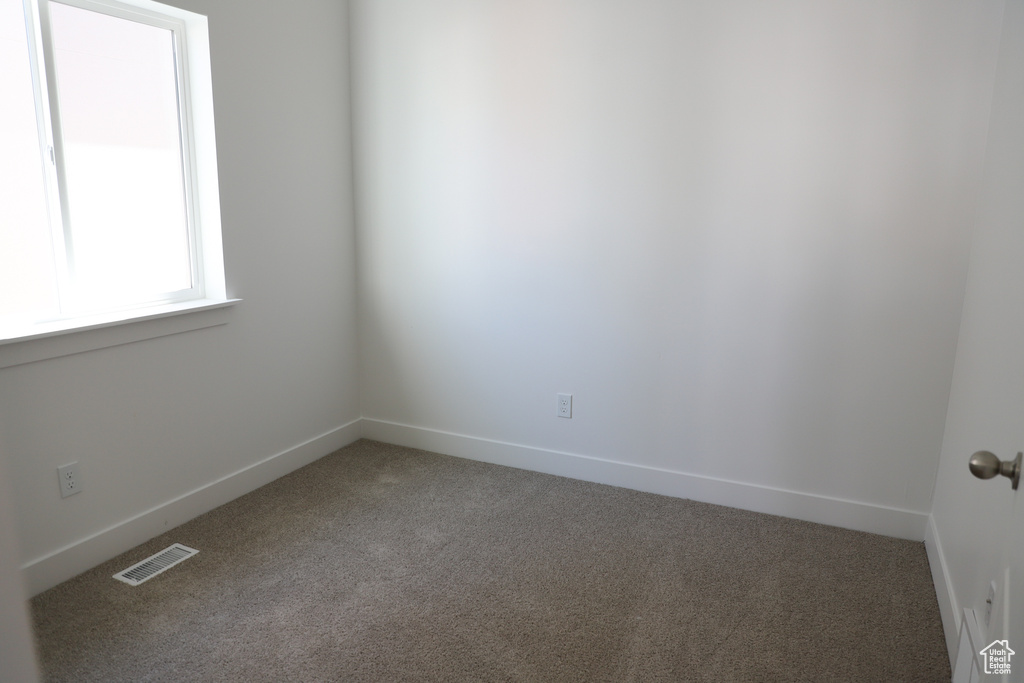 Carpeted empty room with baseboards