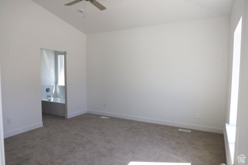 Empty room featuring carpet, ceiling fan, and high vaulted ceiling