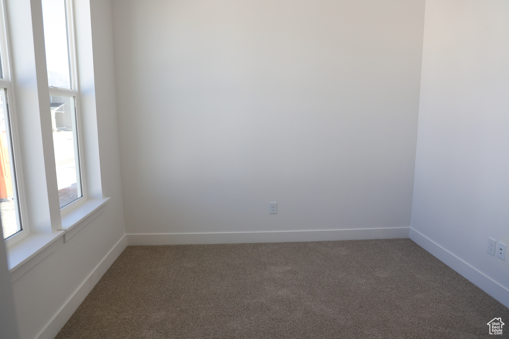 Empty room featuring carpet flooring and baseboards